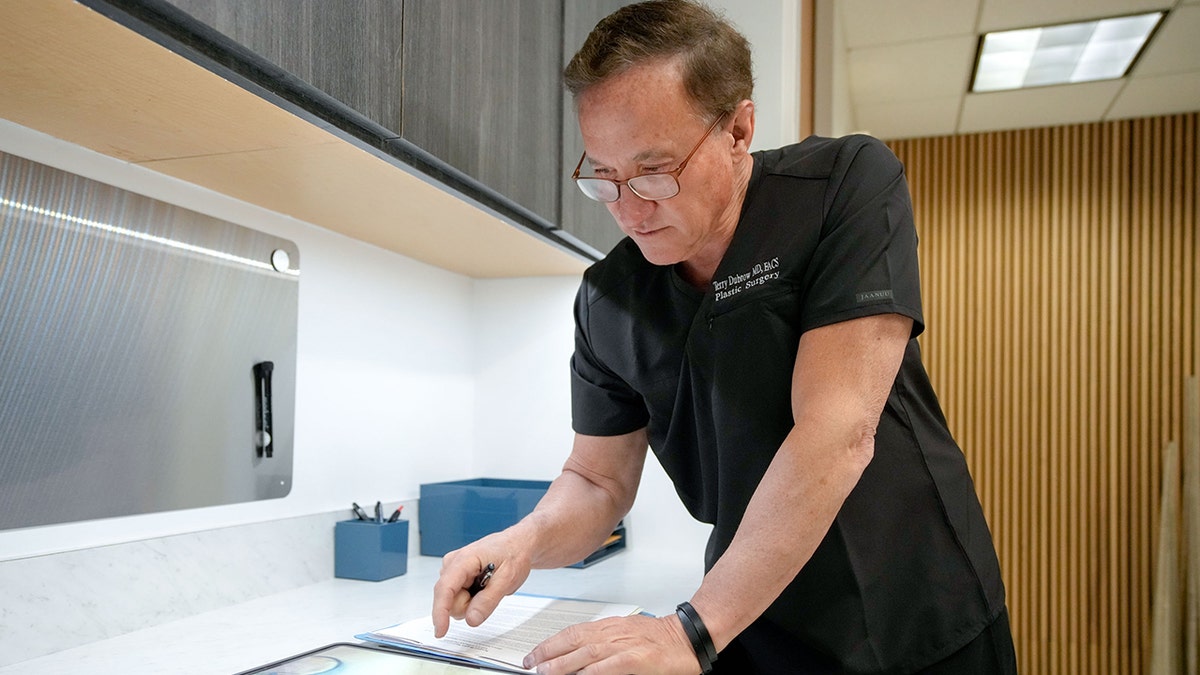 Terry Dubrow arbeitet mit einem iPad in einer Arztpraxis