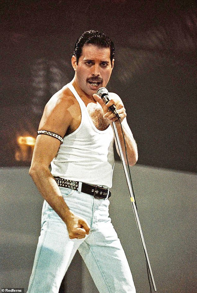 Freddie Mercury posiert, während er bei Live Aid seinen atemberaubenden Gesang ins Mikrofon entfesselt