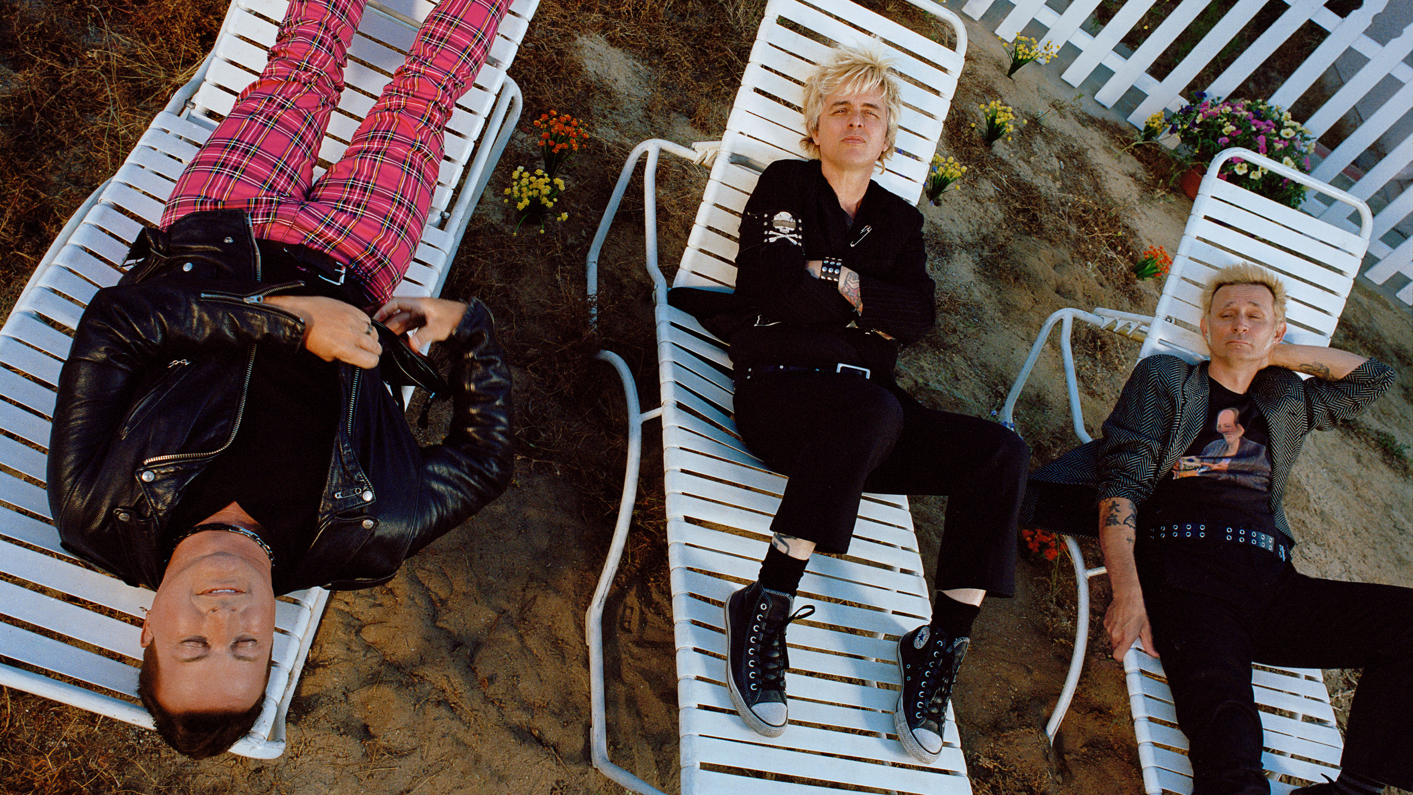Mitglieder der Green Day-Band posieren auf Anwaltsstühlen