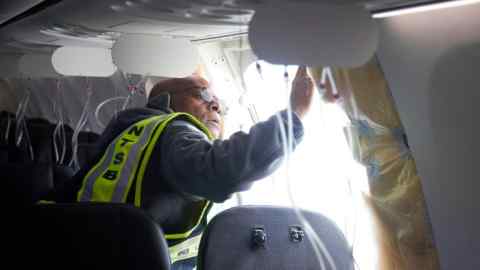 Ein Ermittler untersucht den Rahmen eines Teils des Flugzeugs der Alaska Airlines