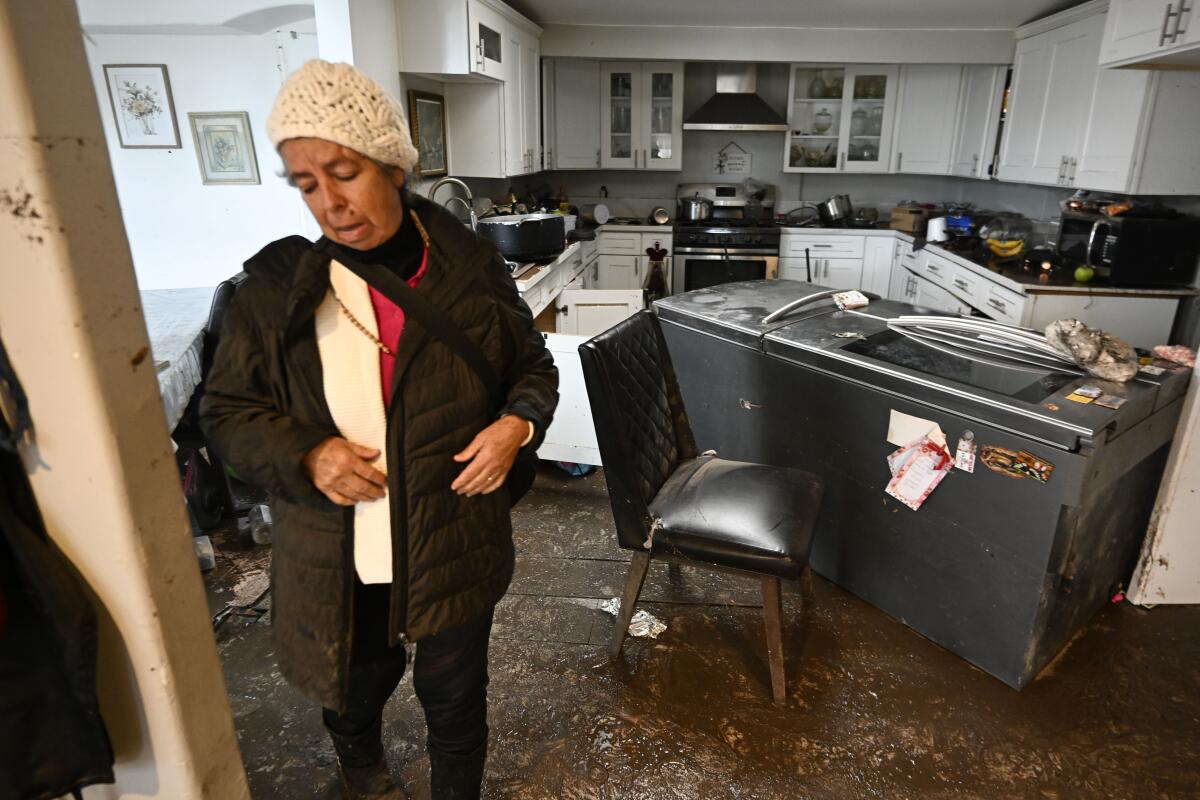 Eine Frau schaut sich ihr vom Hochwasser beschädigtes Haus an 