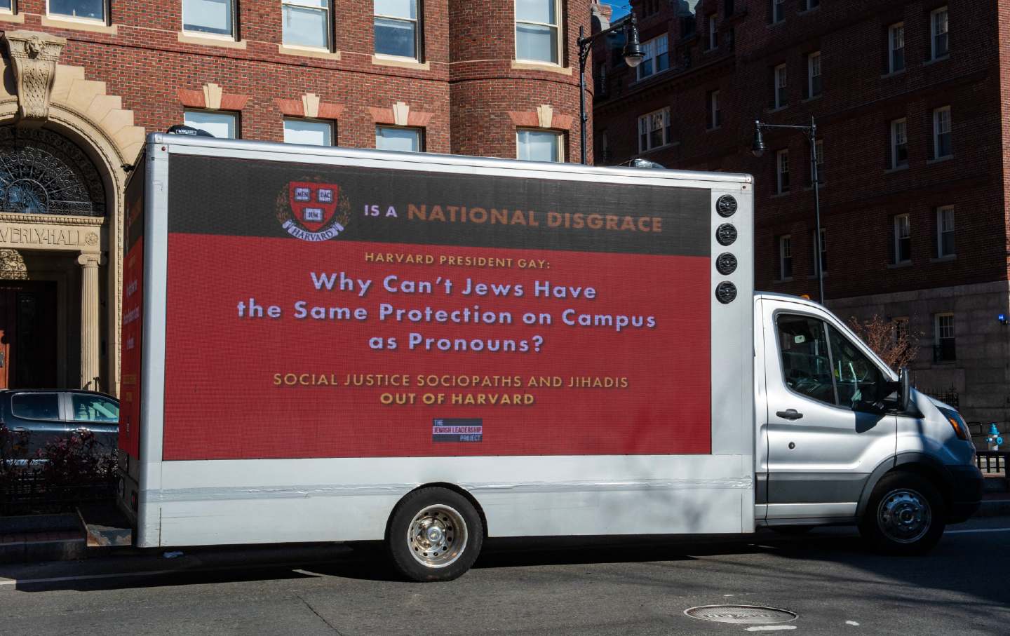 Ein Lastwagen mit einem Schild, auf dem der Präsident von Harvard eine Schande genannt wird, fährt am 12. Dezember 2023 durch die Harvard University in Cambridge, Massachusetts.
