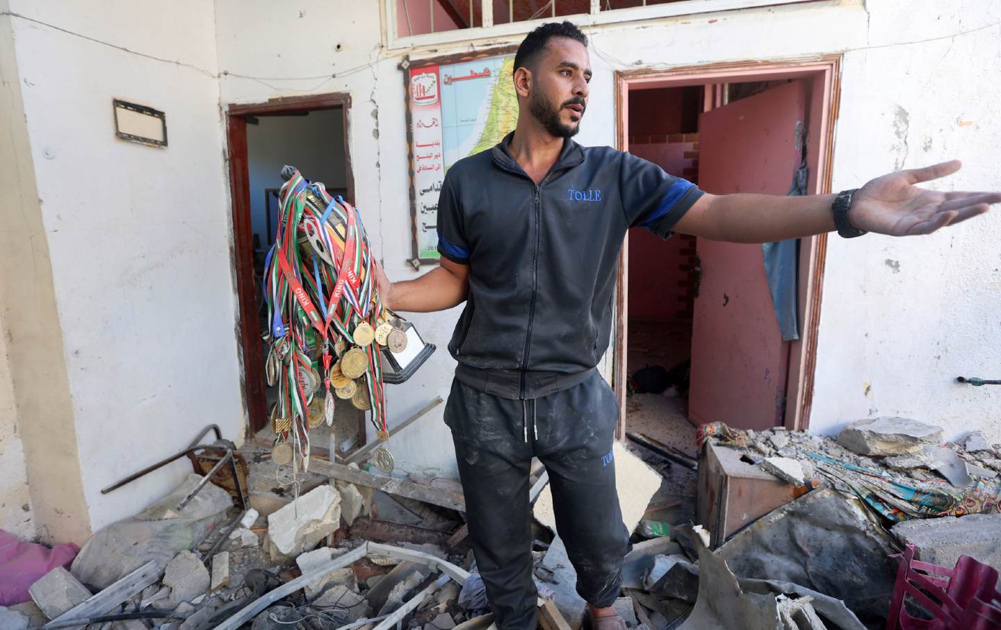 Der ehemalige palästinensische Fußballspieler Said al-Kurd trägt geborgene Medaillen aus seinem zerstörten Familienhaus, wo acht seiner Familienmitglieder bei einem israelischen Granatenangriff in Rafah im südlichen Gazastreifen am 30. Oktober 2023 getötet wurden.
