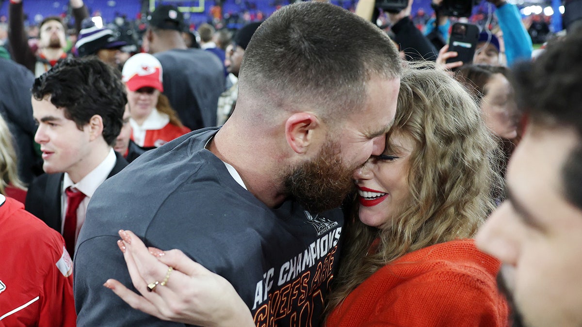 Travis Kelce beugt sich vor, um Taylor Swift beim Spiel der Kansas City Chiefs zu küssen