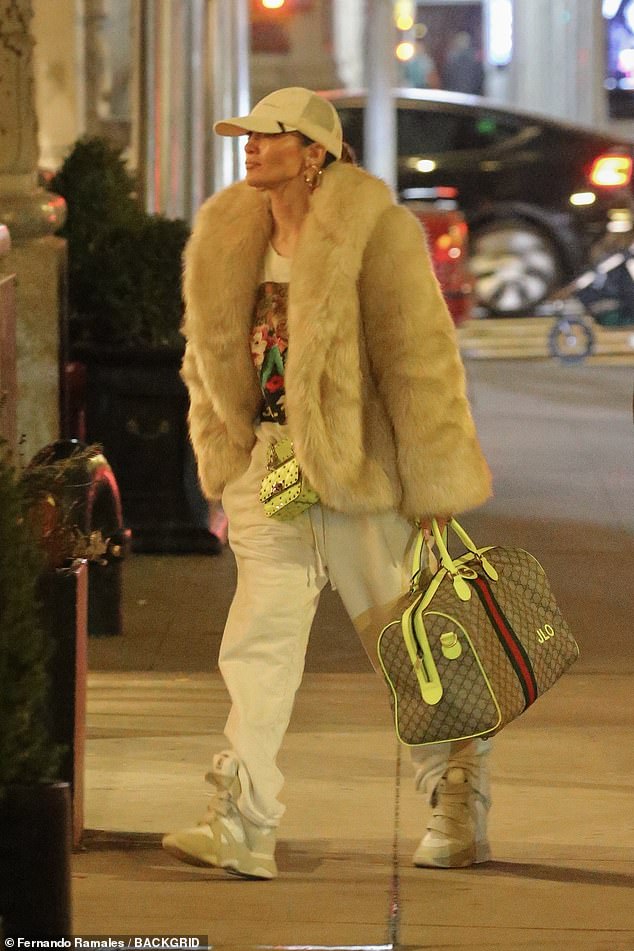 Der Star trug außerdem eine kleine mintgrüne Valentino-Handtasche und eine Gucci-Reisetasche mit dem Monogramm „JLO“.