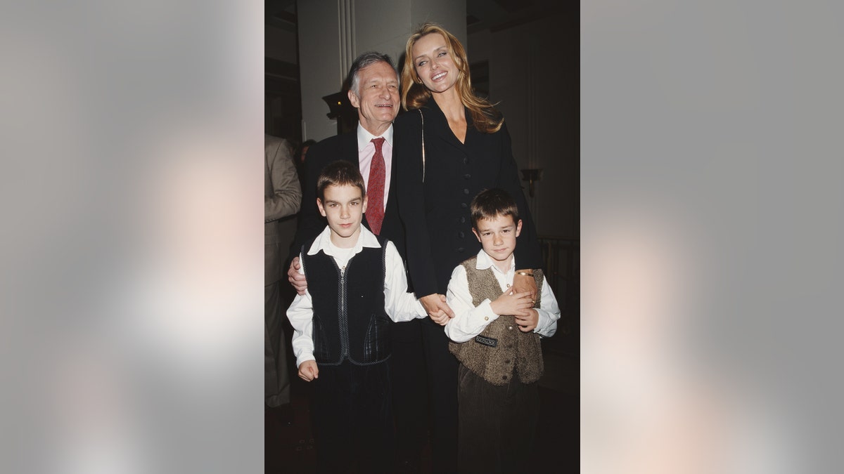 Hugh Hefner lächelt neben seiner Ex-Frau und seinen beiden Söhnen