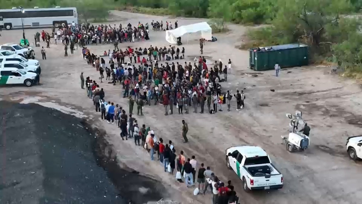 Grenzschutzbeamte bearbeiten eine große Gruppe von Migranten in Eagle Pass, Mexiko
