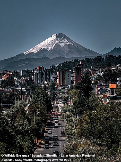 Wilfrido Enriquez steht hinter der Linse dieses auffälligen Bildes des Vulkans Cotopaxi, das Dutzende Kilometer entfernt in Quito in Ecuador aufgenommen wurde.  Es steht auf der Shortlist des Lateinamerika-Regionalpreises