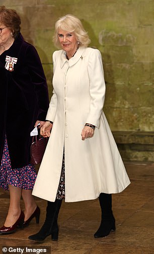 She donned an elegant white coat, which she paired with black heeled boots