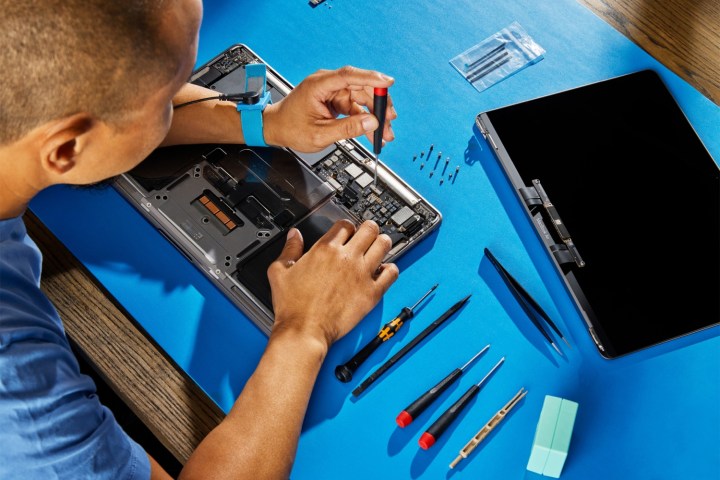 Eine Person repariert ein MacBook mit dem Selbstbedienungs-Reparaturset von Apple.