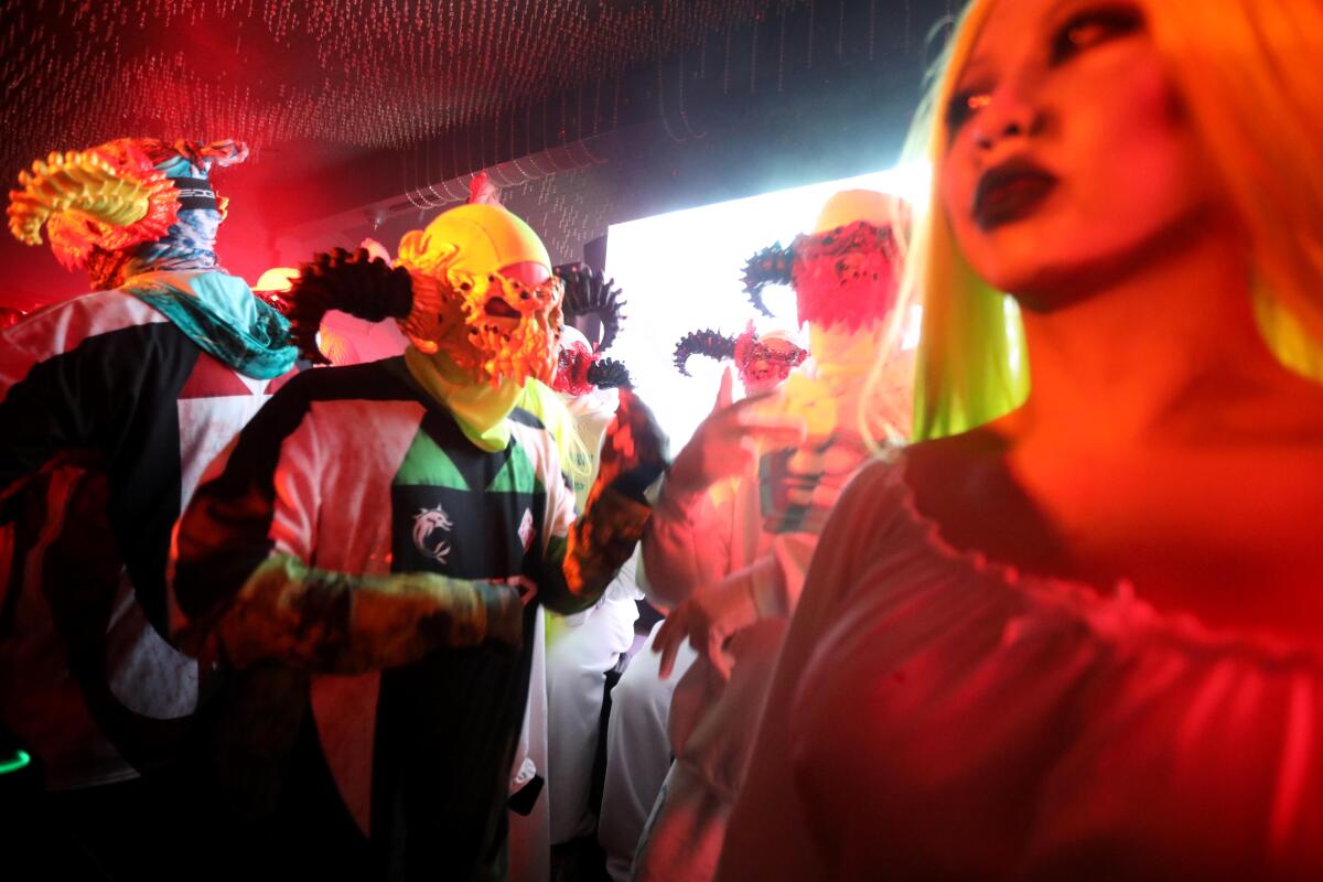 Ein maskierter DJ unterhält auf einer Party.
