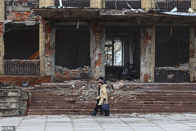 A couple walks near the rubble of destroyed buildings in Kupiansk, Kharkiv region, Ukraine, 08 February 2024, amid the Russian invasion