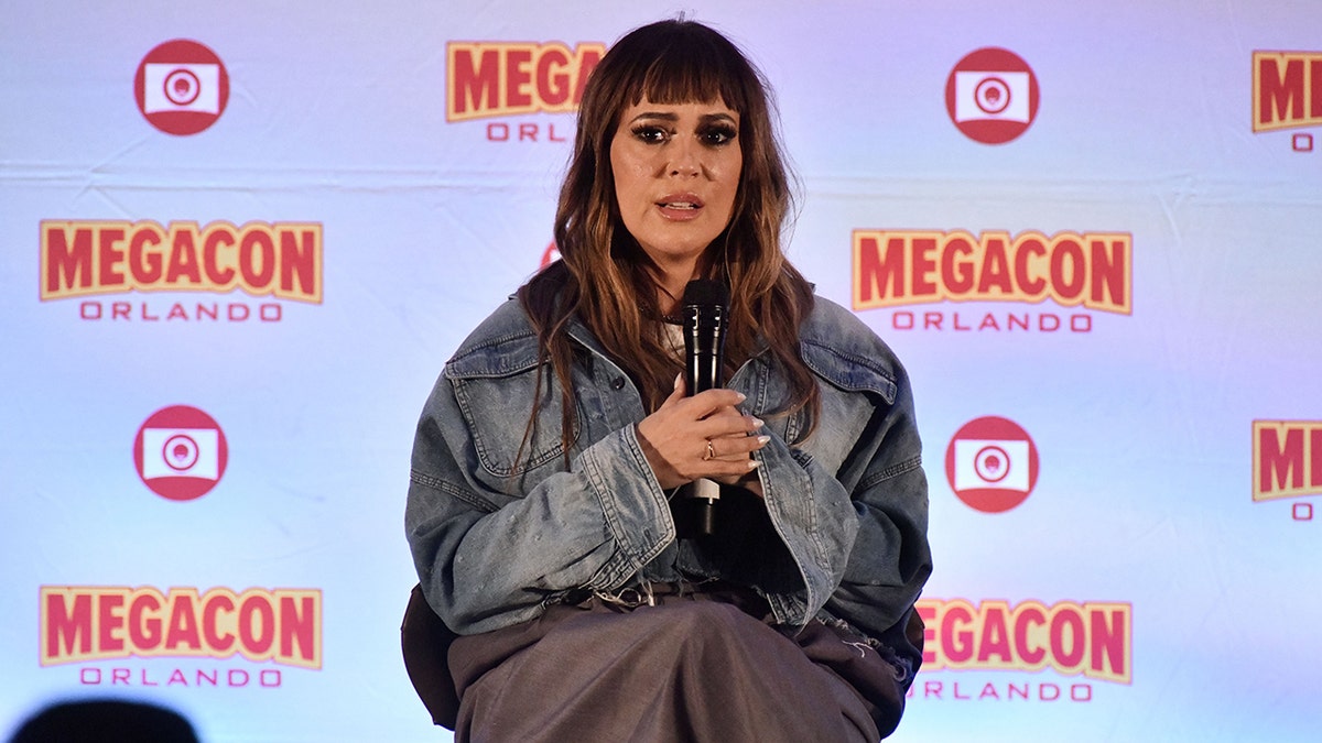 Alyssa Milano sieht in einer Jeansjacke auf der Bühne der MegaCon Orlando ernst aus