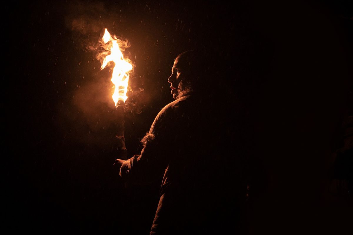 In „Out of Darkness“ steht ein paläolithischer Mann mit einer Taschenlampe in absoluter pechschwarzer Dunkelheit, mit dem Rücken zur Kamera