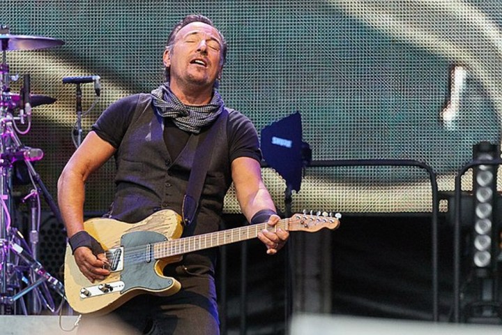Bruce Springsteen hält seine Gitarre bei einem Konzert.