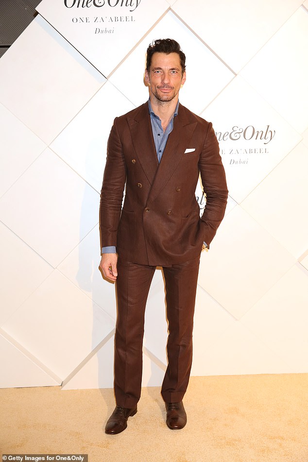David Gandy cut a dapper figure in a chocolate brown suit which he teamed with a blue shirt left open at the collar