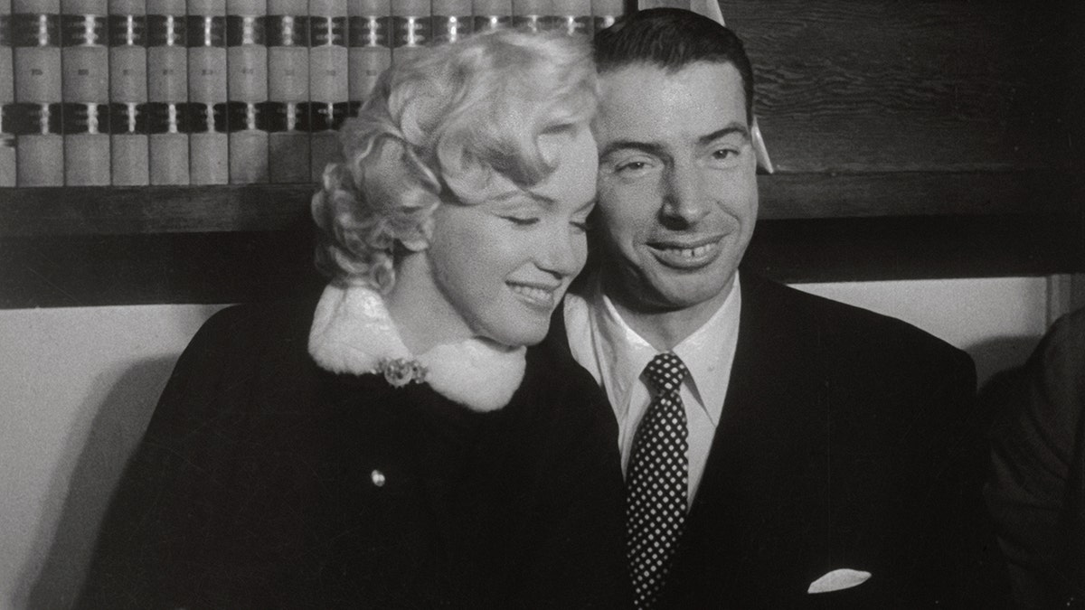 Marilyn Monroe stützt sich an ihrem Hochzeitstag auf Joe DiMaggio