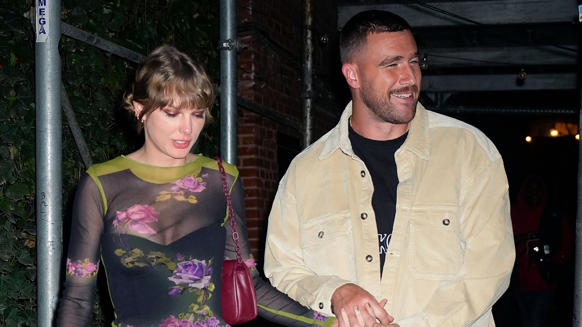 Taylor Swift in einem Blumenoutfit läuft neben ihrem Freund Travis Kelce