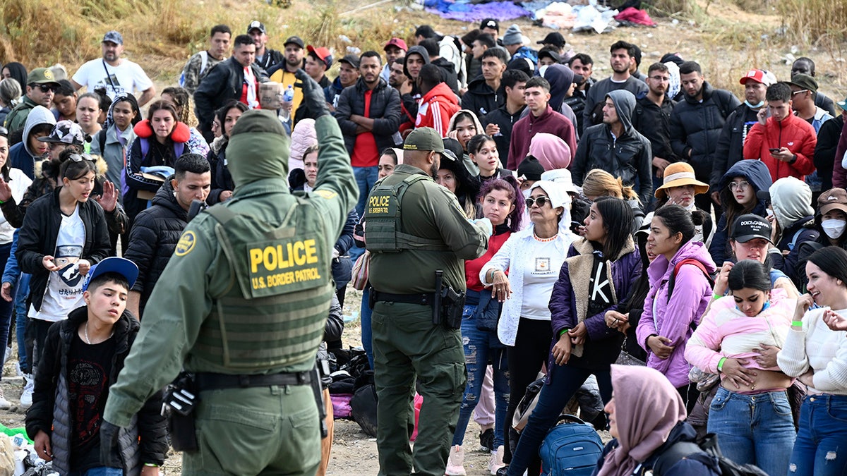 Grenzschutz verteilt Armbänder an große Gruppe von Migranten