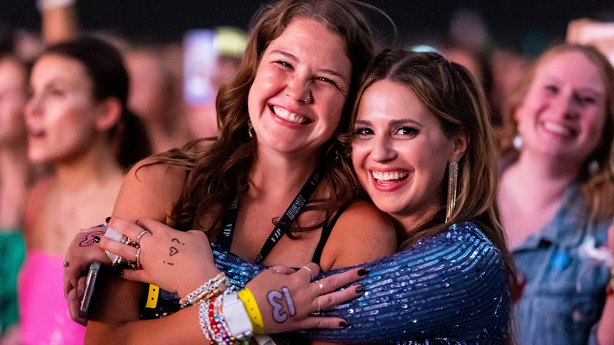 Zwei Fans lächeln bei der Eras Tour in Atlanta und zeigen die 13er auf ihren Händen