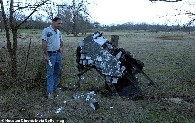 Mac Powell steht 2003 auf seinem Grundstück in Nacogdoches County, Texas neben dem, was er für den vermutlich beschädigten linken Flügel der abgestürzten Raumfähre Columbia hält