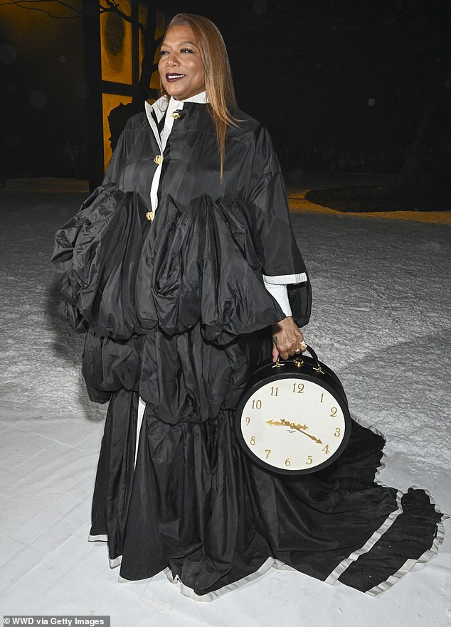 Queen Latifah also made a statement while at the Thom Browne show on Wednesday, and wowed in a black coat that contained layered fabric around the midriff as well as a train for a dramatic flare