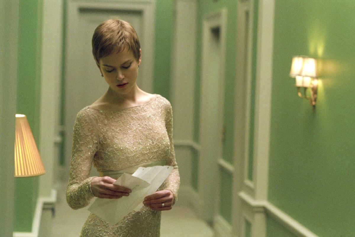 Schauspielerin Nicole Kidman betrachtet ein Blatt Papier in einem Flur mit grünen Wänden und weißen Verzierungen