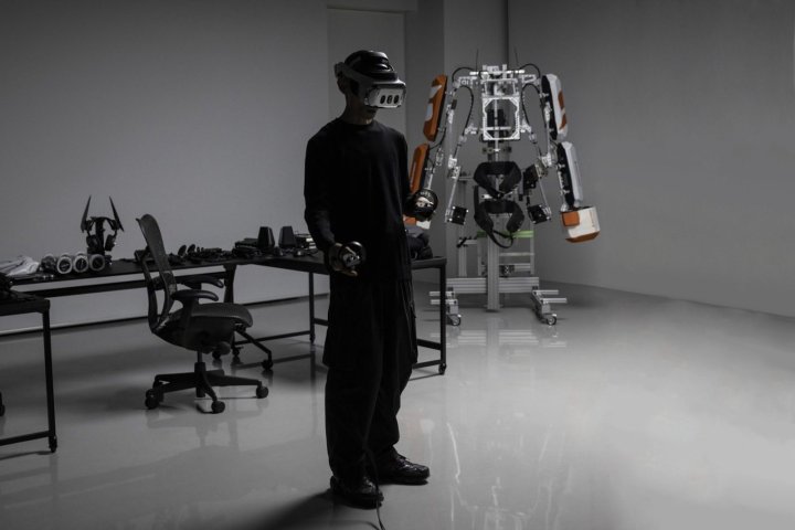 Ein Varjo X-4 VR-Headset wird von einer Person getragen, die vor einem Roboter-Exoskelett steht.