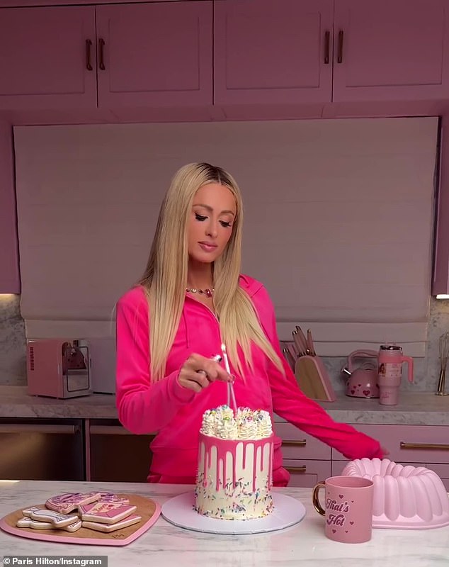 Sie war in ihrer rosa Küche und steckte eine rosa Kerze in ihren rosa-weißen Kuchen