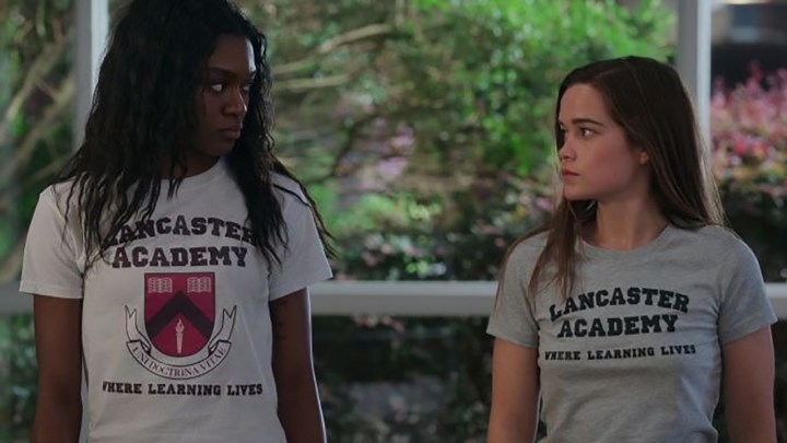 In einer Szene aus „First Kill“ auf Netflix schauen sich zwei junge Frauen an, beide tragen High-School-T-Shirts.