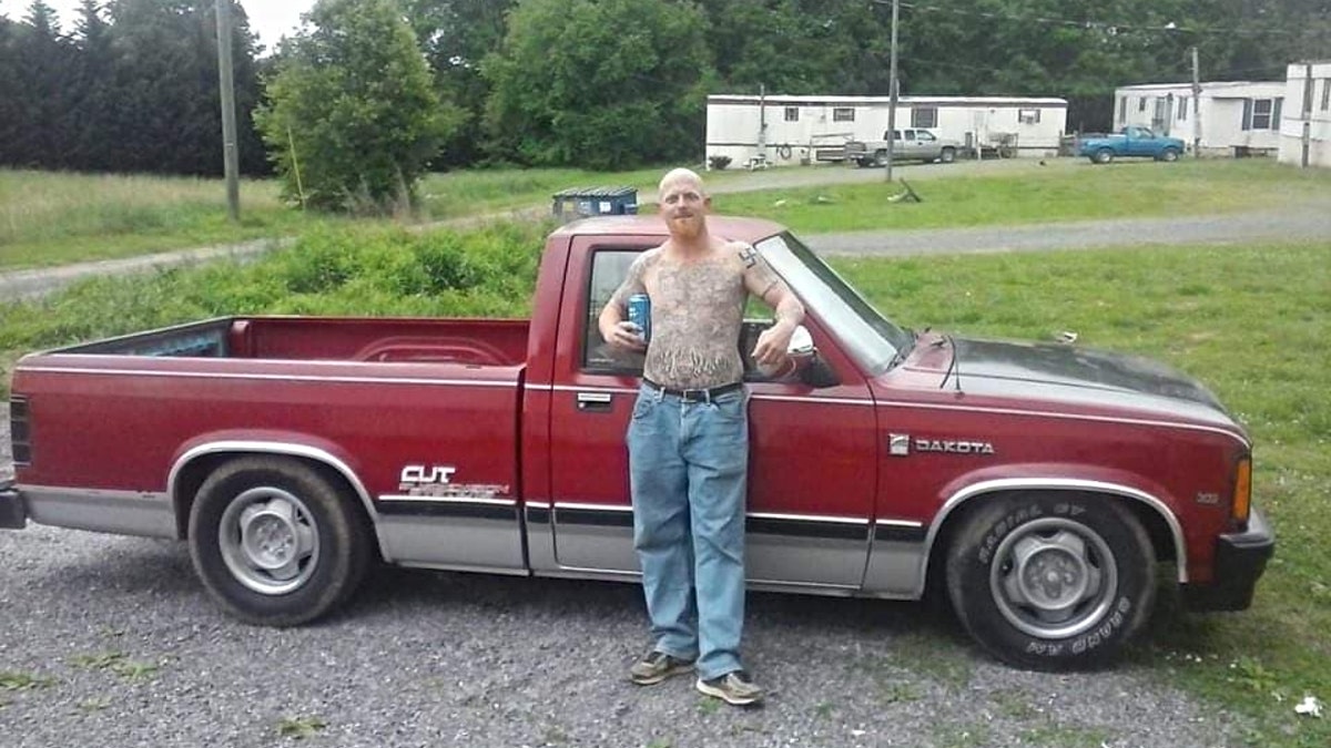 Don Steven McDougal posiert ohne Hemd neben einem Lastwagen