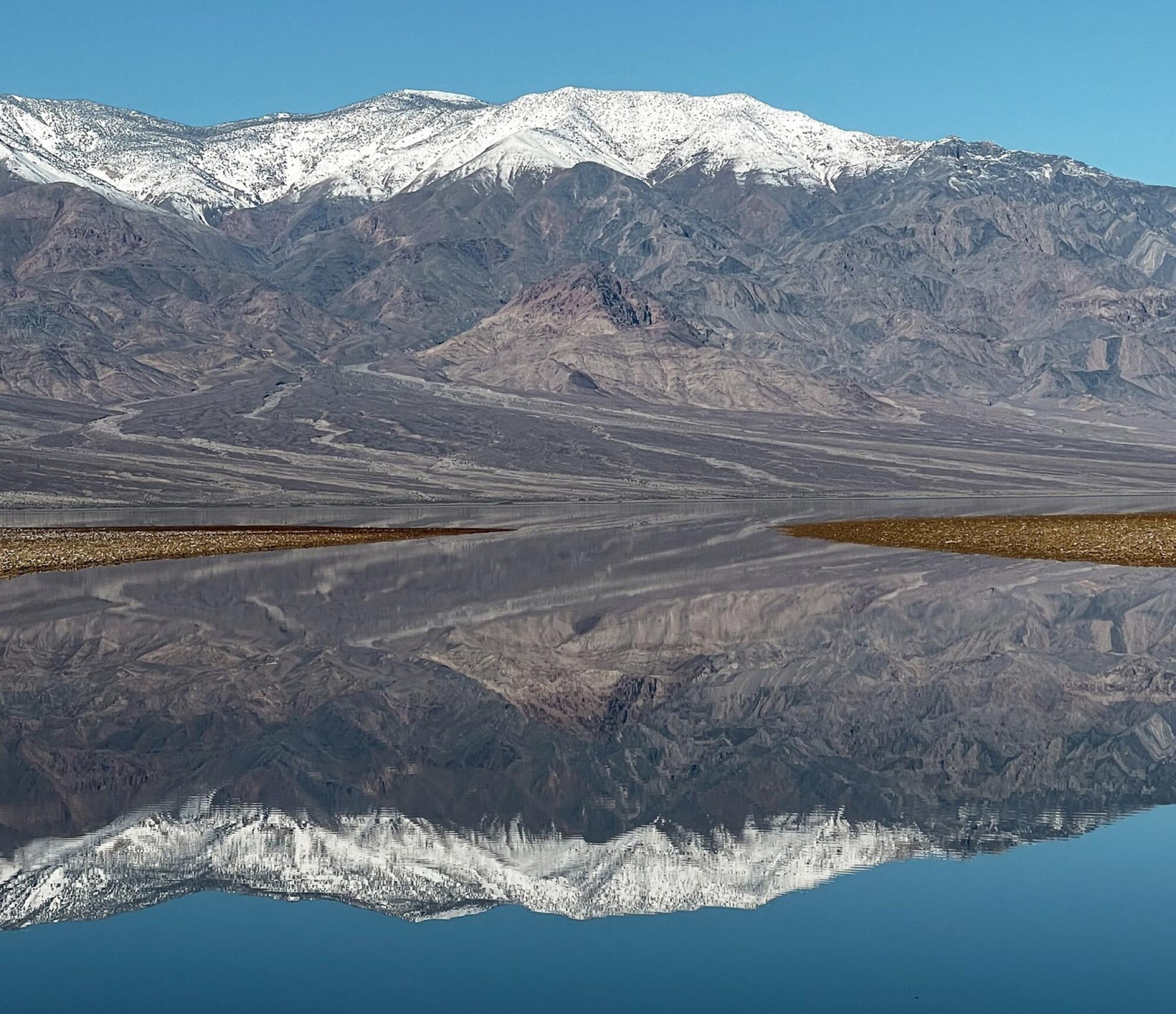 Reflexionen von einem wassergefüllten Badwater Basin im Death Valley National Park am 12. Februar 2024.