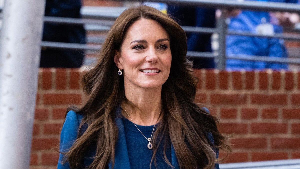 Kate Middleton lächelt im blauen Anzug