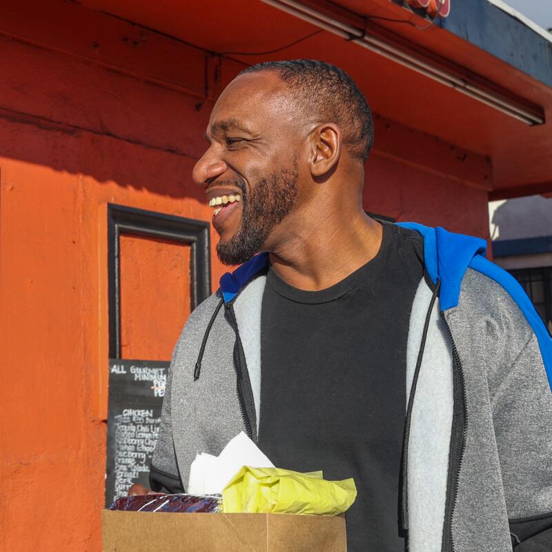 Los Angeles, CA – 8. Februar: James Paschall lächelt, nachdem er seine Tacos und seinen Burrito erhalten hat.