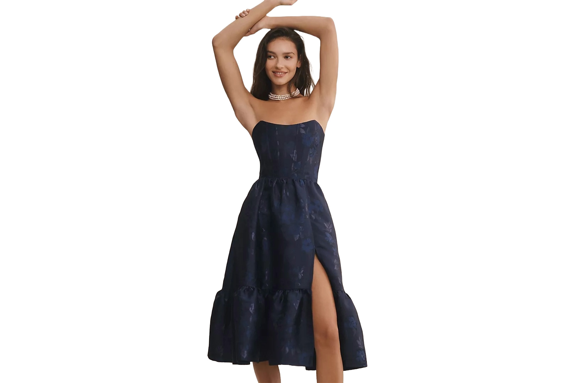 Ein Model in einem trägerlosen marineblauen Kleid mit Schlitz