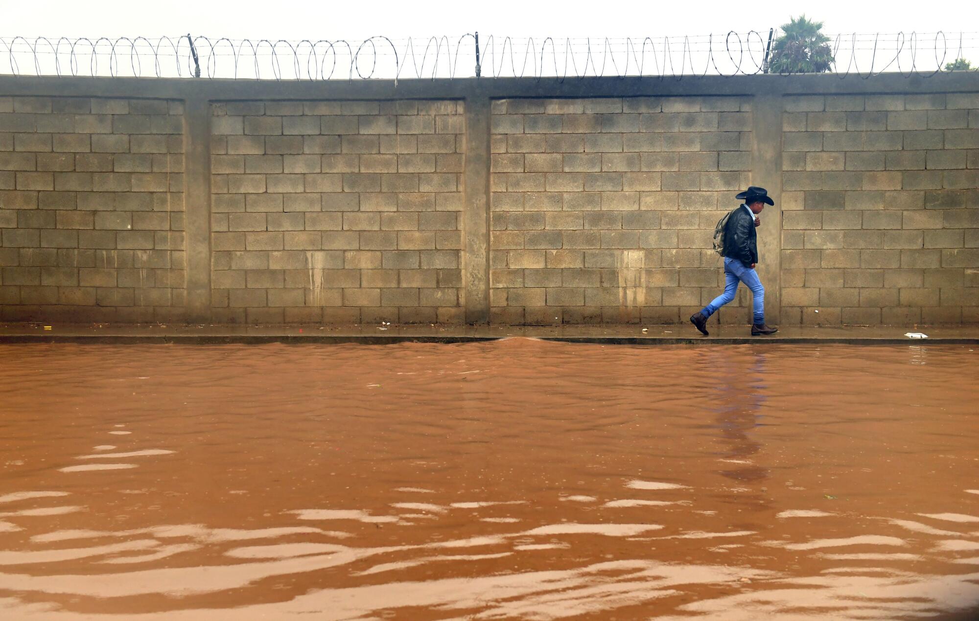 Ein Fußgänger meidet eine überflutete Straße.