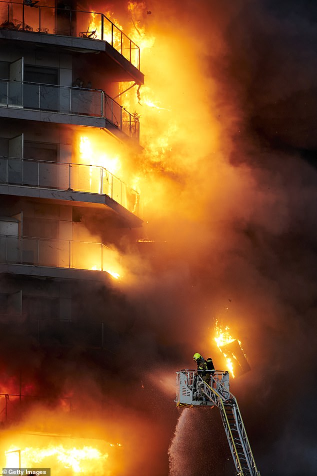 Brennende Trümmer stürzten um die Feuerwehrleute herab, die daran arbeiteten, das Inferno zu löschen