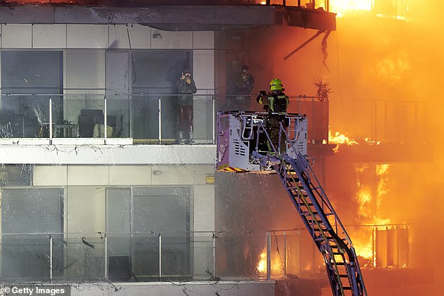 Feuerwehrleute setzten Kräne ein, um Menschen aus dem brennenden Gebäude zu retten
