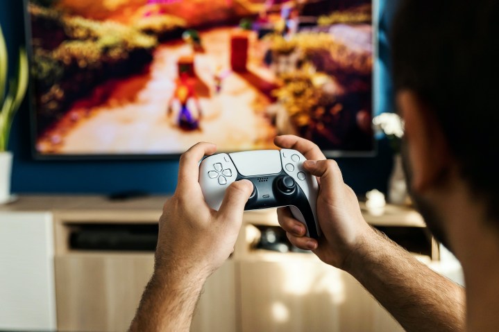 Eine Person spielt Crash Bandicoot mit einem PS5 DualSense-Controller.