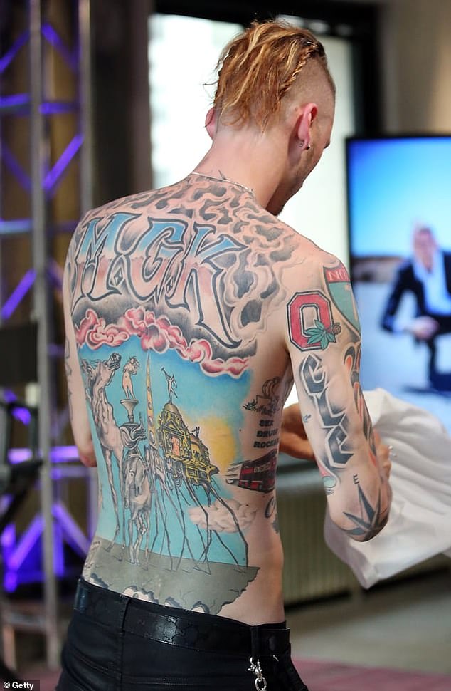 Das vielleicht herausragendste von Kellys Tattoos ist das große "MGK" Ein Stück breitete sich in Ombre-Rosa und Blau über seinen oberen Rücken aus