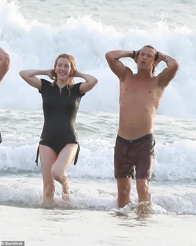 Das Paar taucht nach einem Bad aus dem Meer auf