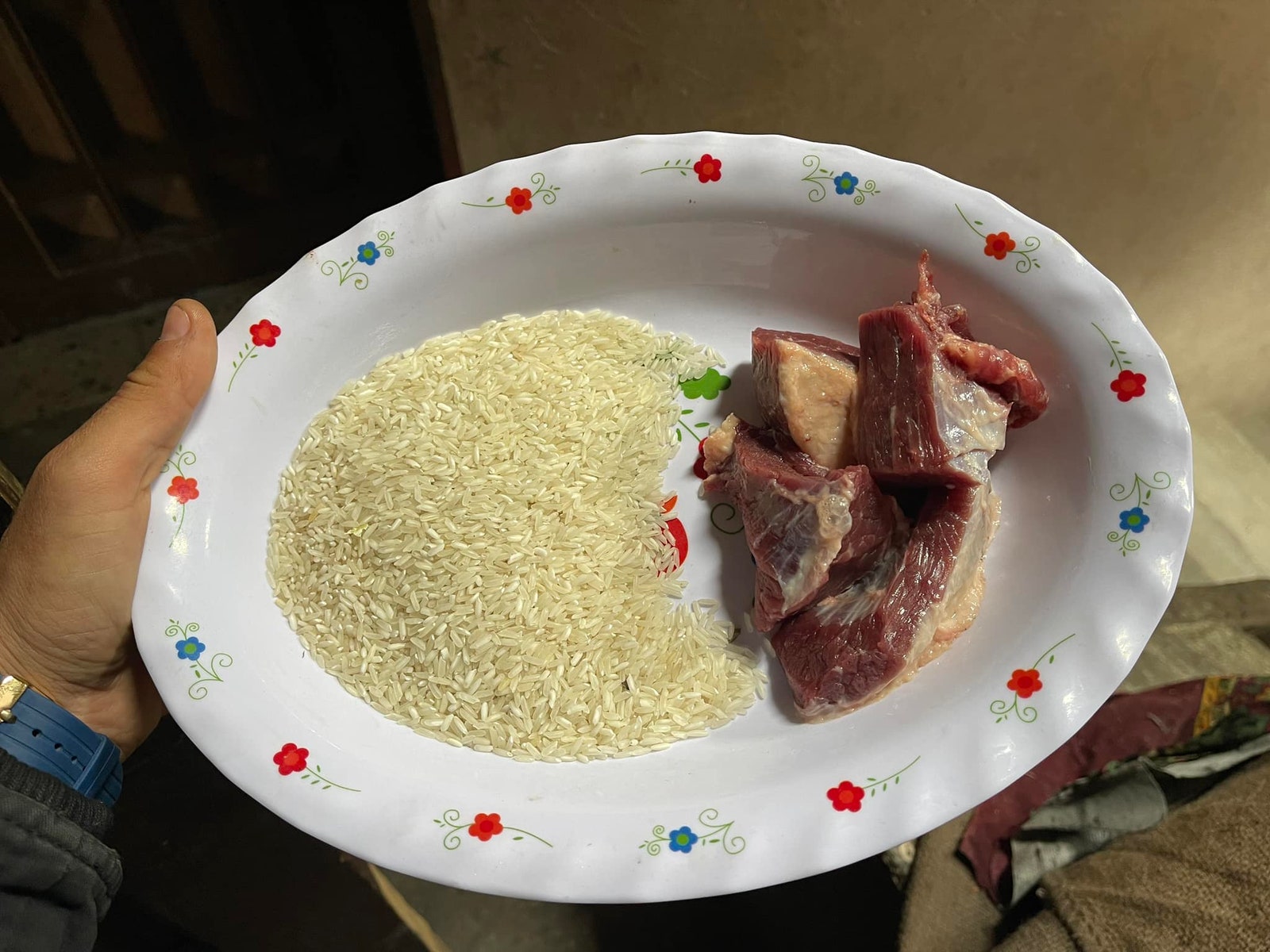 Foto eines Tellers mit Reis und rohem Fleisch in Gaza.