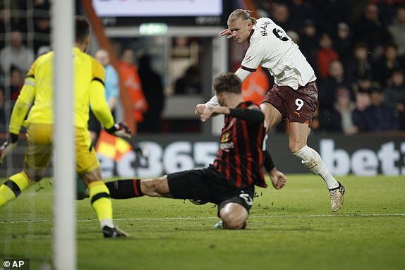 Manchester City's Erling Haaland, right, attempts a shot on goal during the English Premier League soccer match between Bournemouth and Manchester City at the Vitality stadium in Bournemouth, England, Saturday, Feb. 24, 2024. (AP Photo/David Cliff)