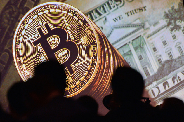 An image of Bitcoin and US currencies is displayed on a screen.
