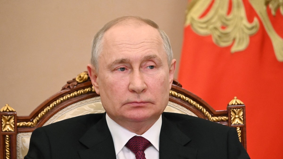 Der russische Präsident Wladimir Putin sitzt im Anzug im Stuhl