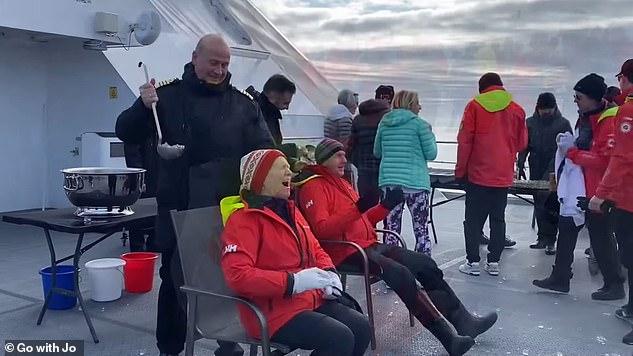 To celebrate crossing the 80th Parallel North, the Captain pours ice down passengers' necks