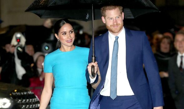 Prinz Harry und Meghan Markle gehen unter einem Regenschirm
