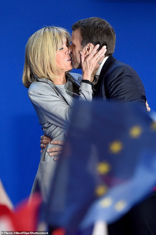 Emmanuel und seine Frau küssen sich zum Feiern nach der ersten Runde der französischen Präsidentschaftswahlen am 23. April 2017 in Paris