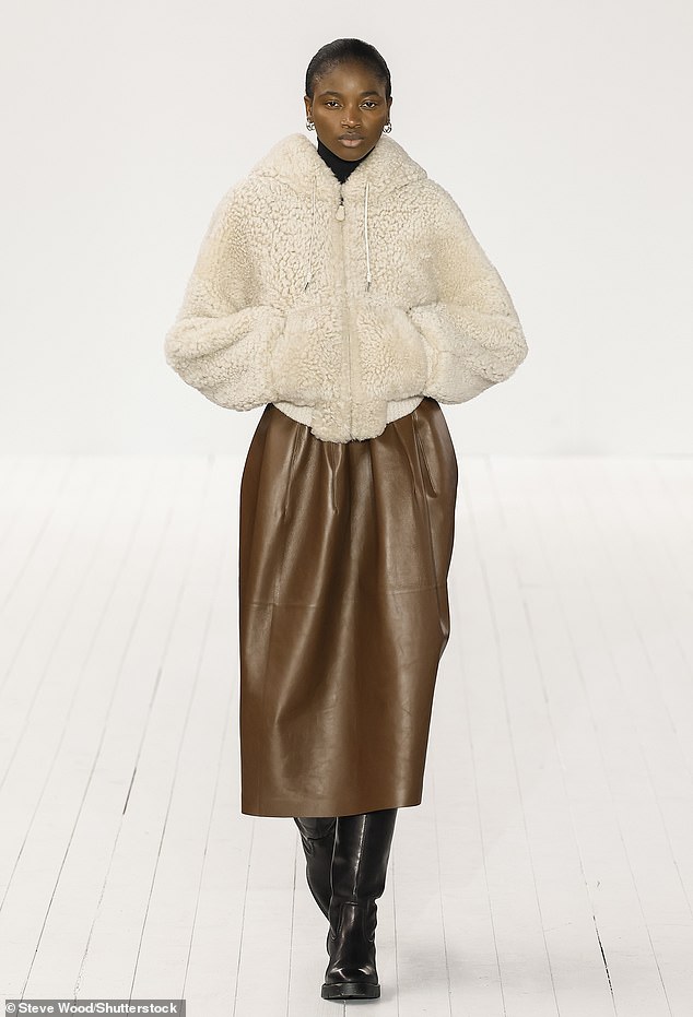 Chloes Herbst/Winter-Show 2023 auf der Paris Fashion Week zeigte ein Model, das cremefarbenes Fleece, gepaart mit einem braunen Leder-Midi und kniehohen Stiefeln trug