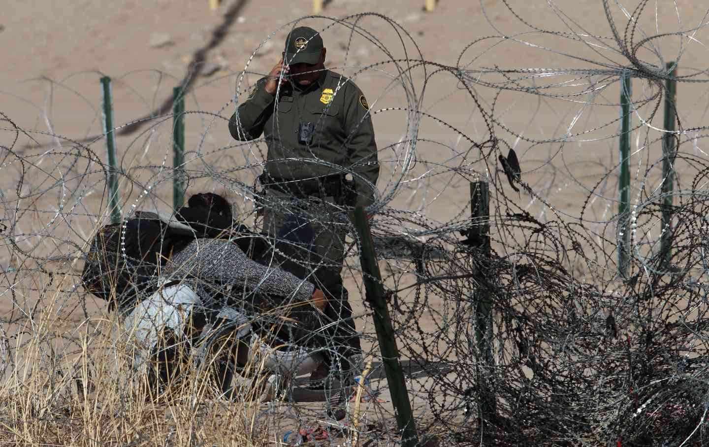 Grenzschutzbeamte ergreifen Sicherheitsmaßnahmen, als Migranten, die versuchen, die Grenze zwischen Mexiko und den Vereinigten Staaten zu überqueren, um humanitäres Asyl zu beantragen, am 31. Januar 2024 in Ciudad Juárez, Mexiko, trotz hoher Sicherheitsmaßnahmen durch Stacheldraht durchtrennt werden.